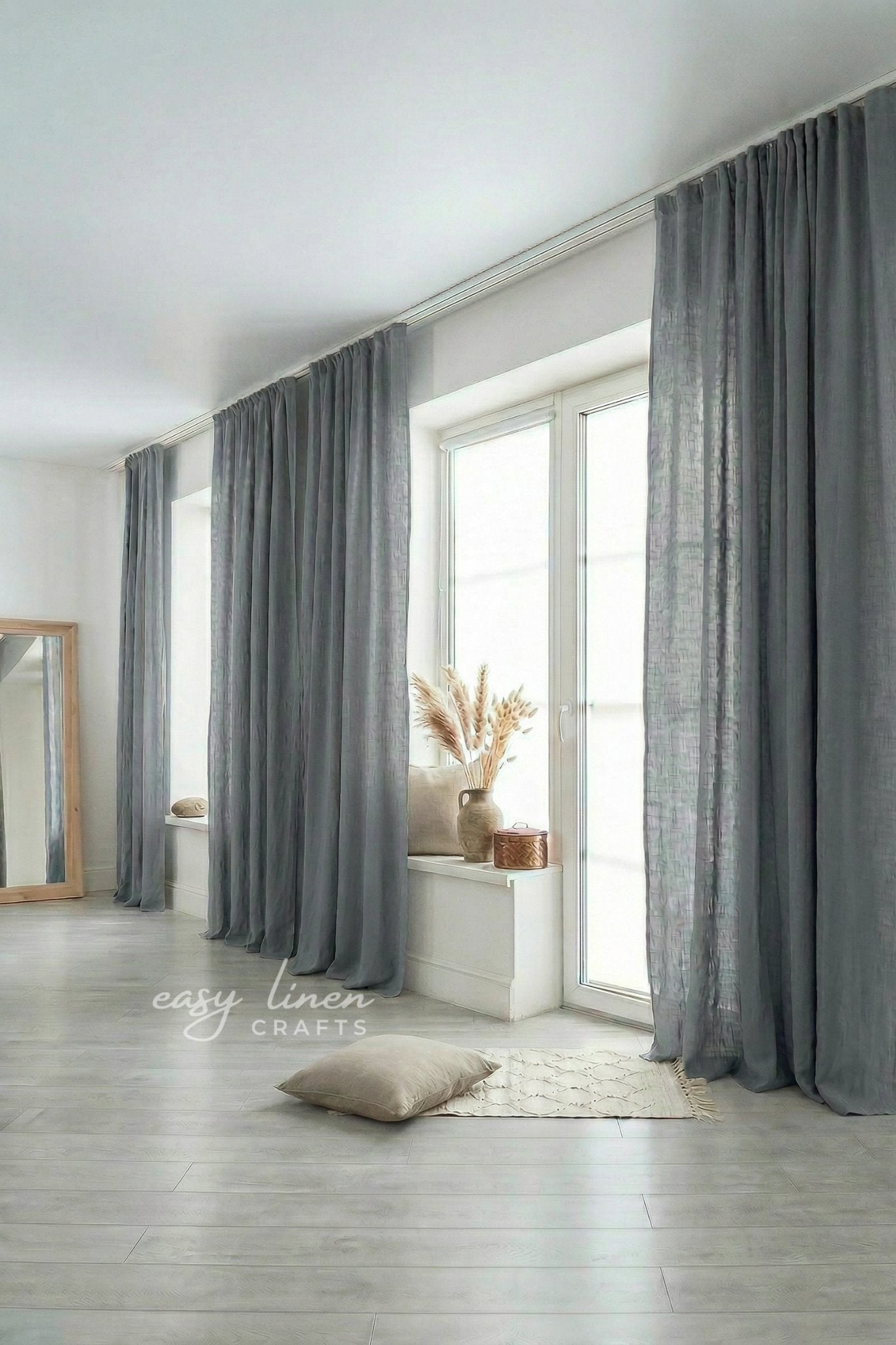 Gray curtains in a room with a window and light-colored floor.