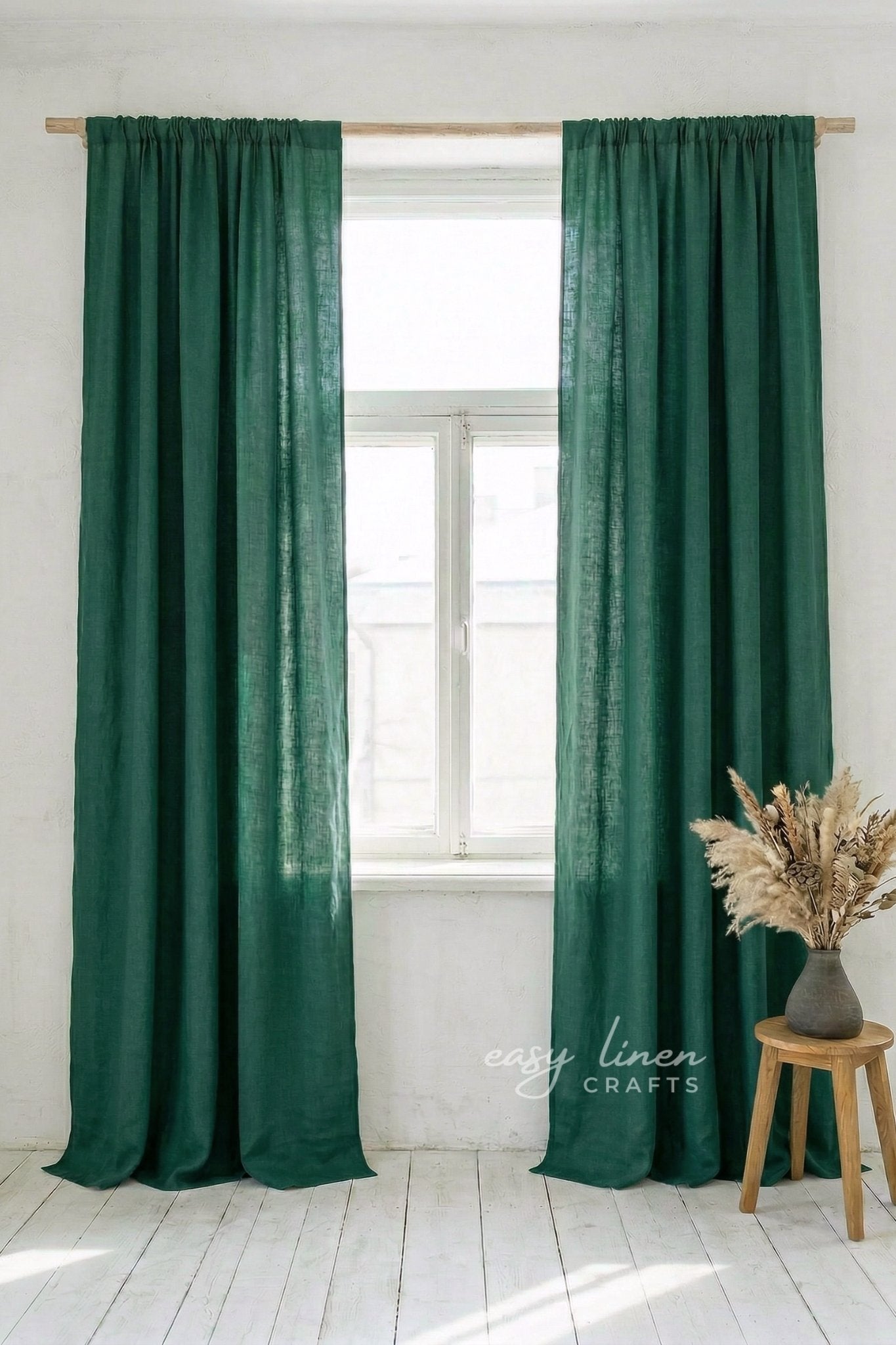 Green curtains hanging on a window with a white background