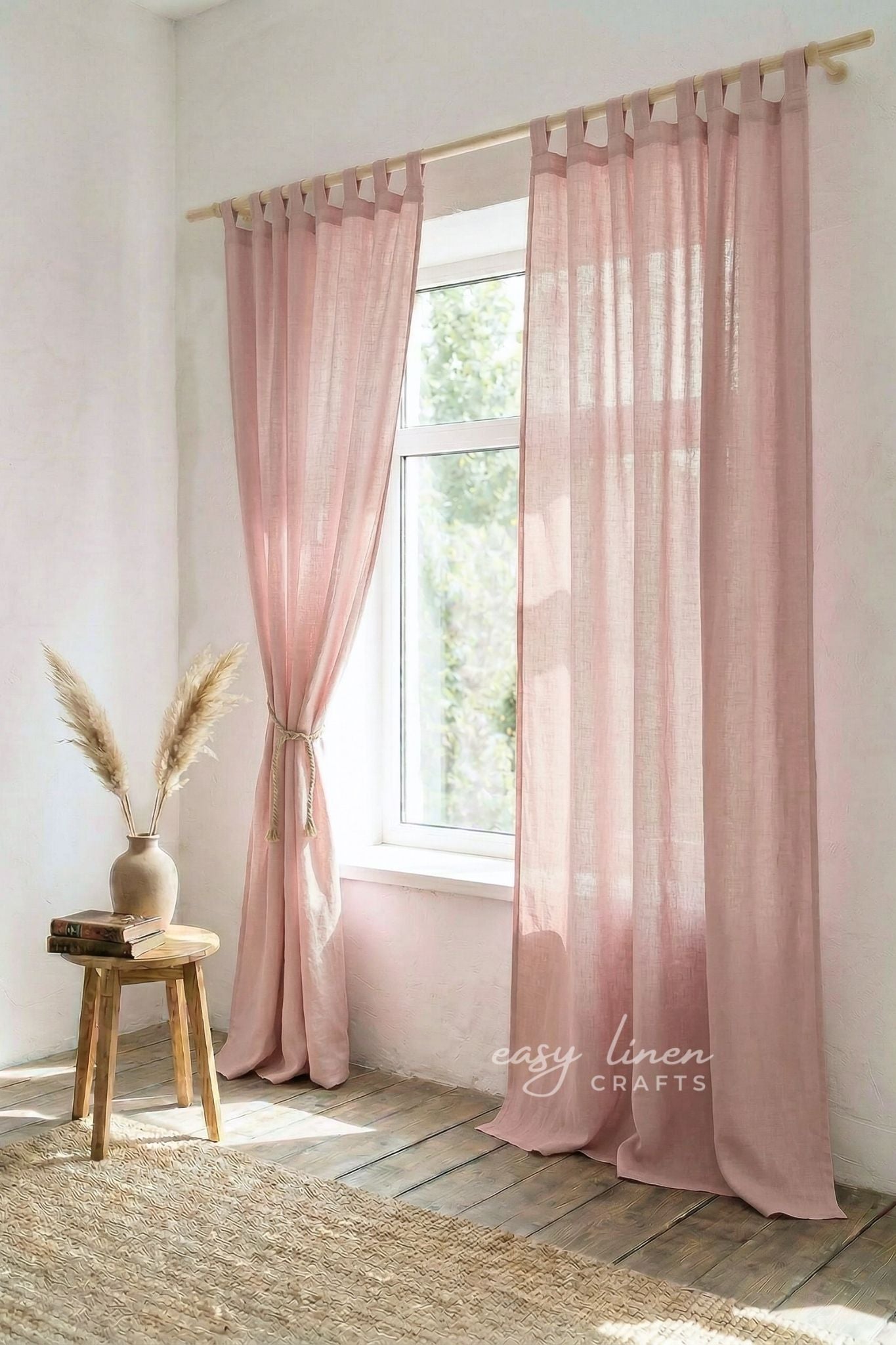 Pink curtains hanging in a room with a wooden stool and vase.