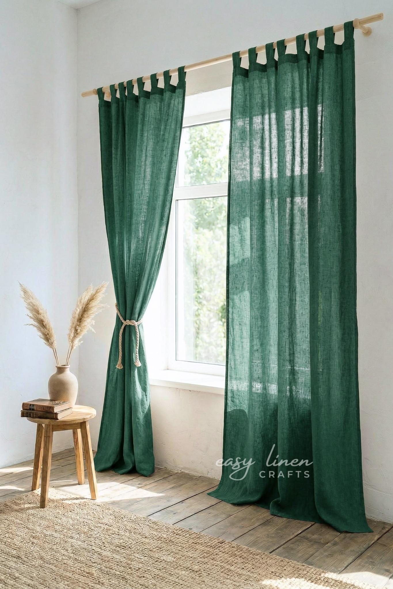 Green curtains with wooden rod and stool in a room with natural light