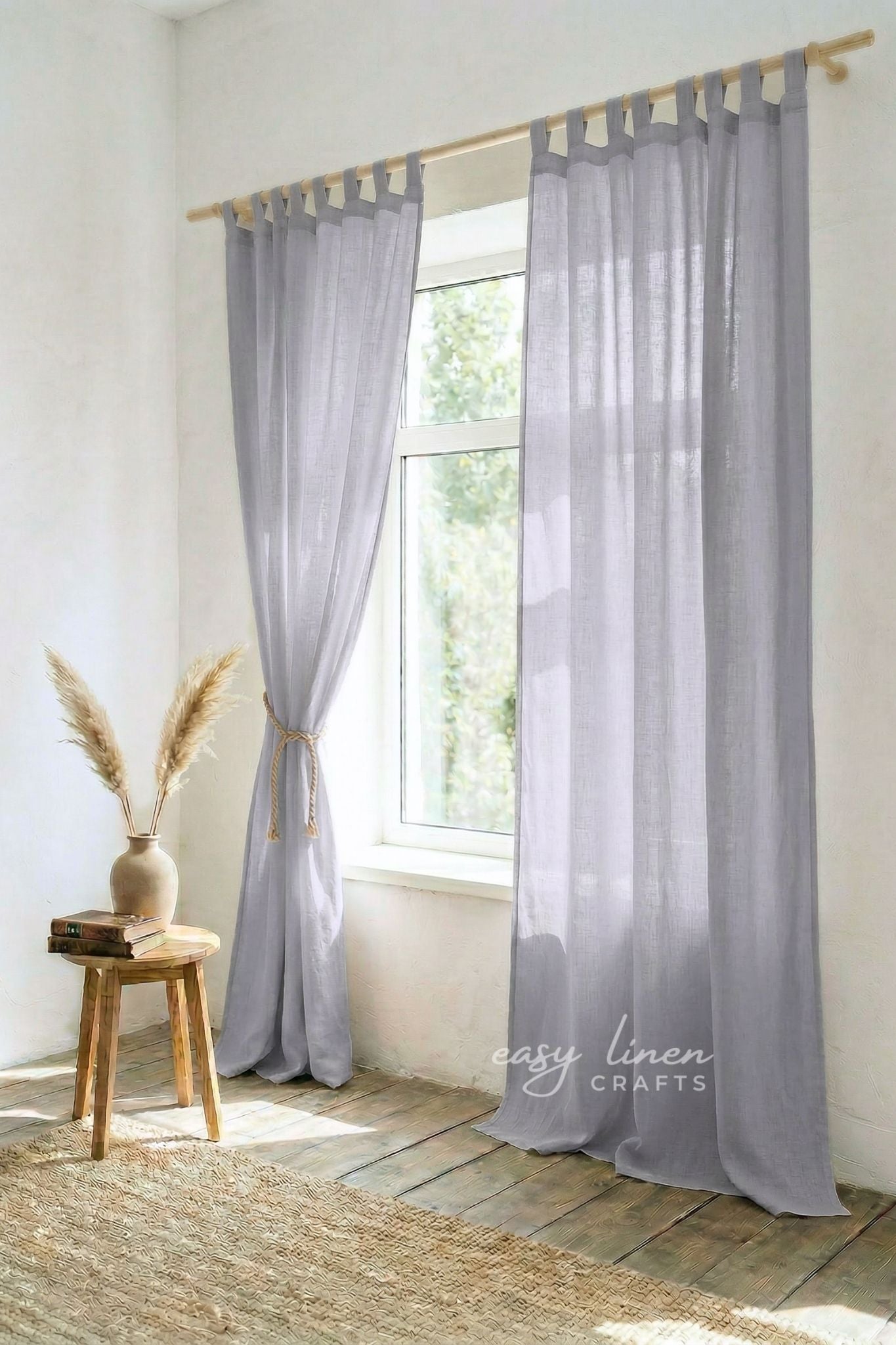 Sheer gray curtains with wooden rod and stool in a room with natural light.