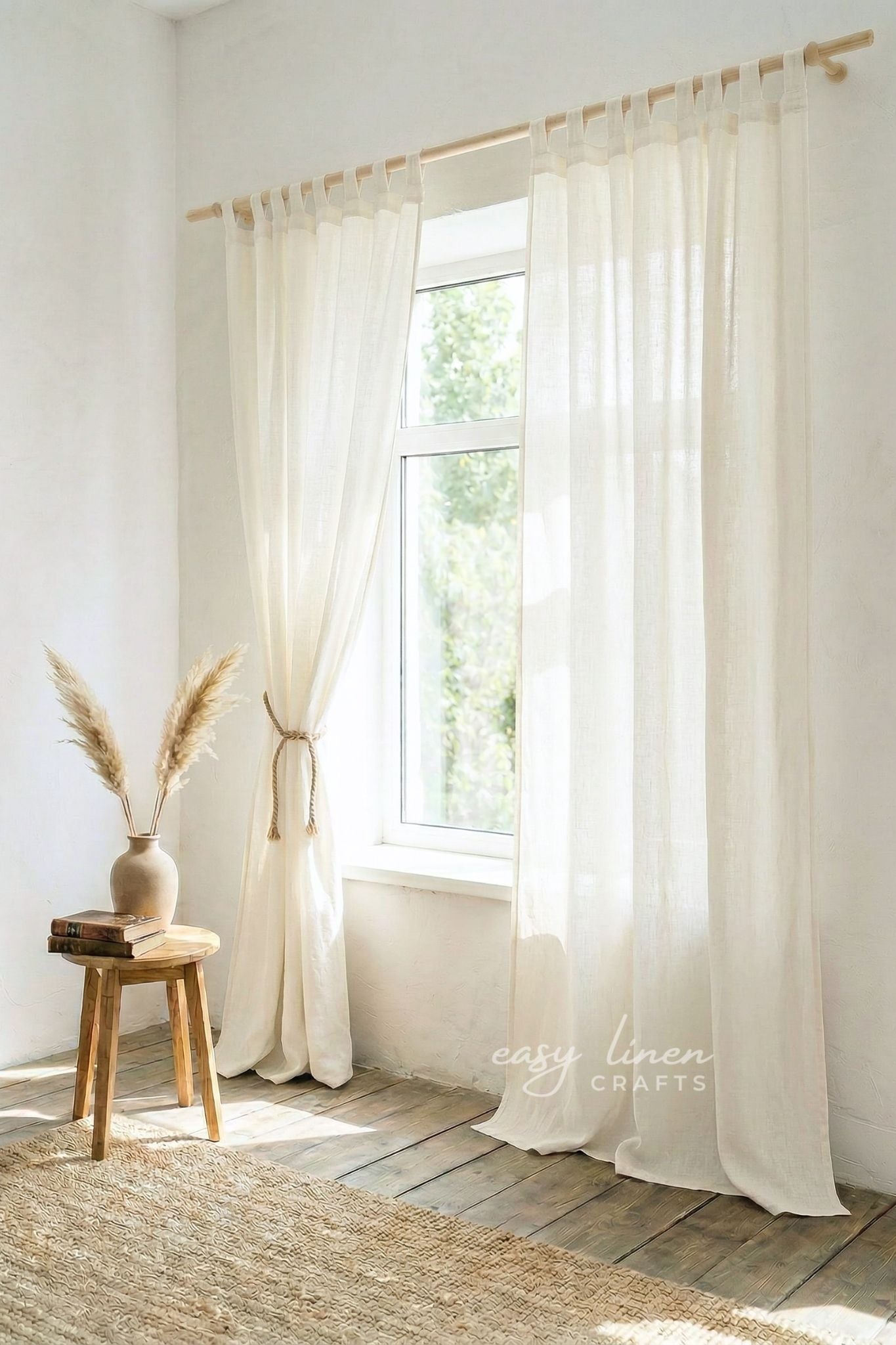 Sheer white curtains hanging in a room with a wooden stool and decorative vase.