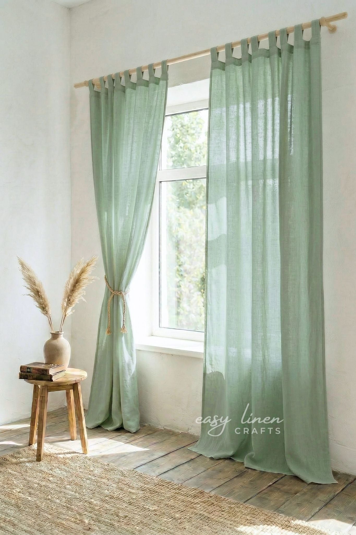Light green curtains hanging in a room with a wooden stool and vase.