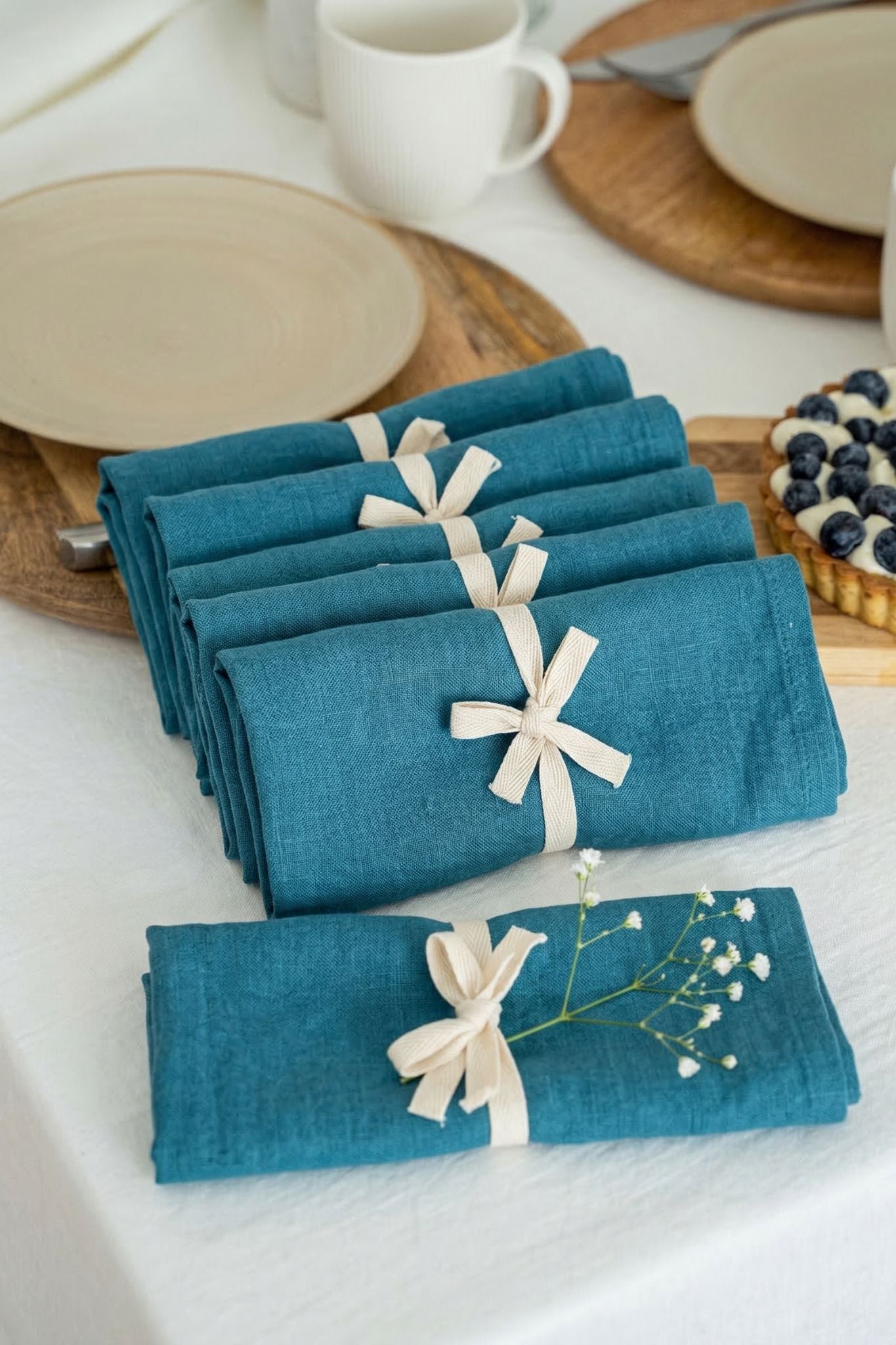 Set of blue napkins with white bows on a table setting.