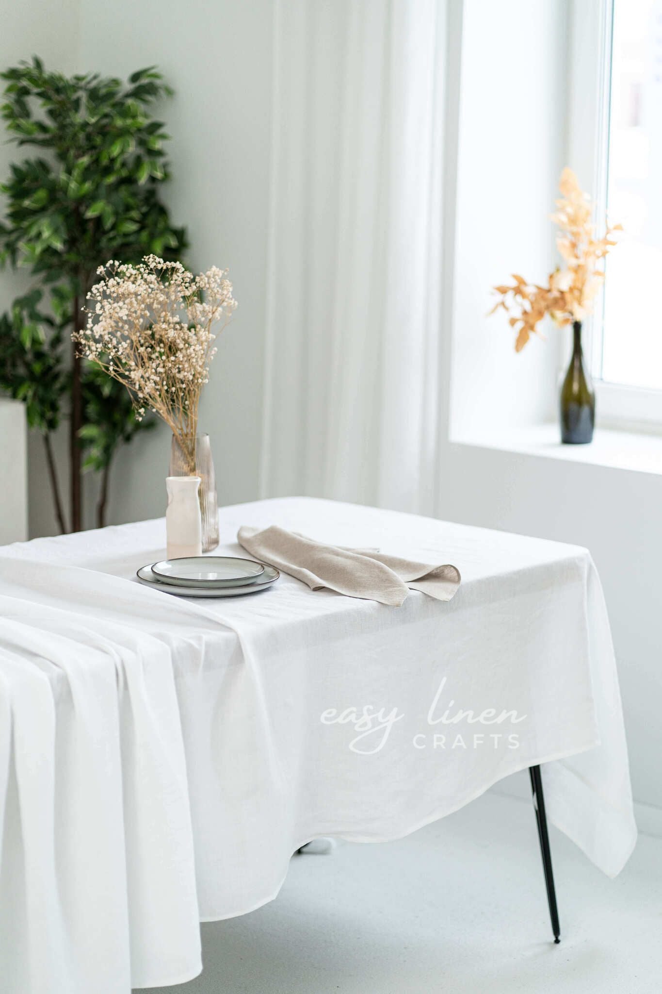 White tablecloth on a table with decorative elements in a bright room.