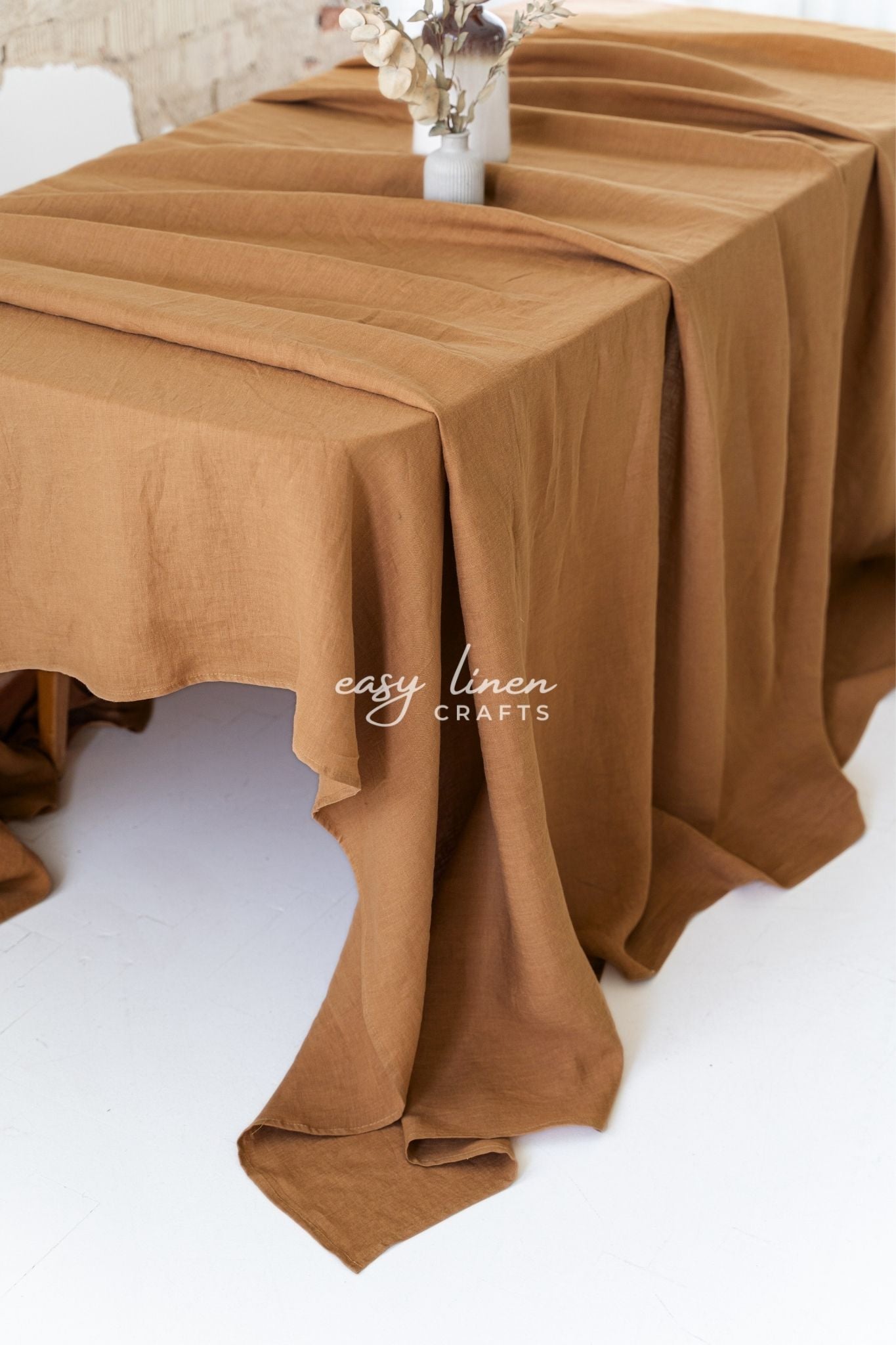 Brown linen tablecloth on a table with 'easy linen crafts' branding.
