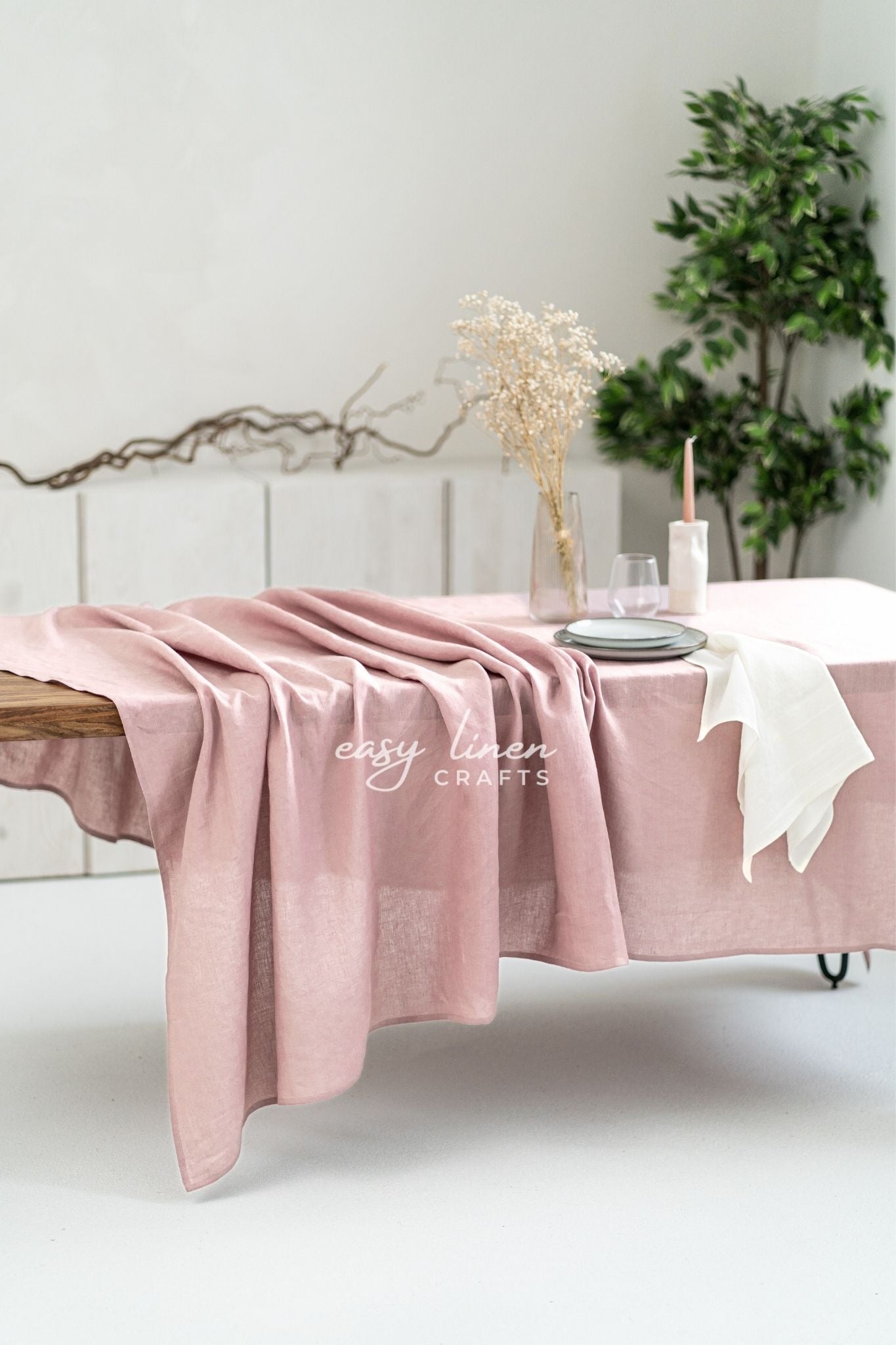 Pink linen tablecloth on a dining table set against a neutral background.