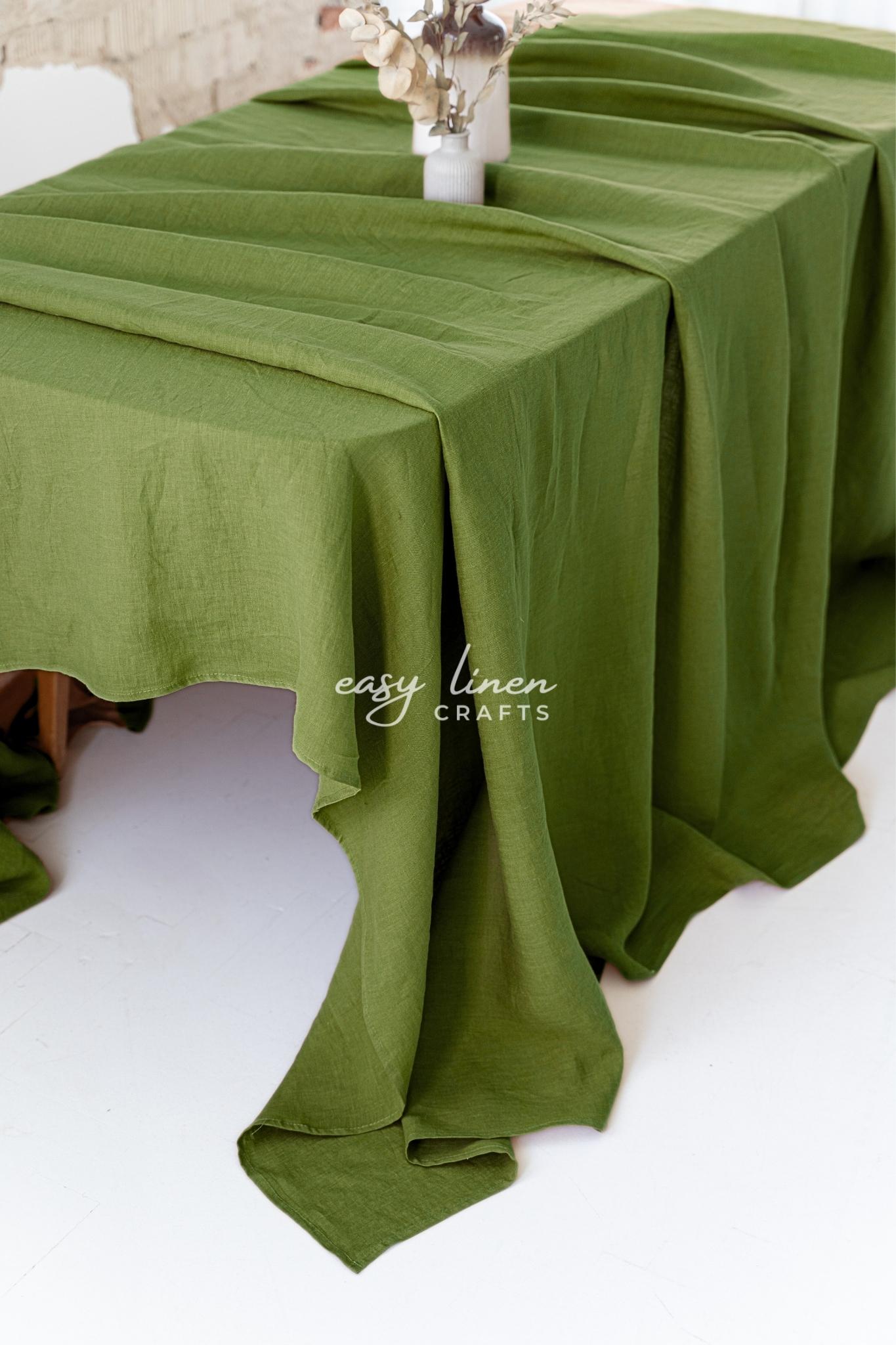 Green linen tablecloth on a table with 'easy linen crafts' branding.