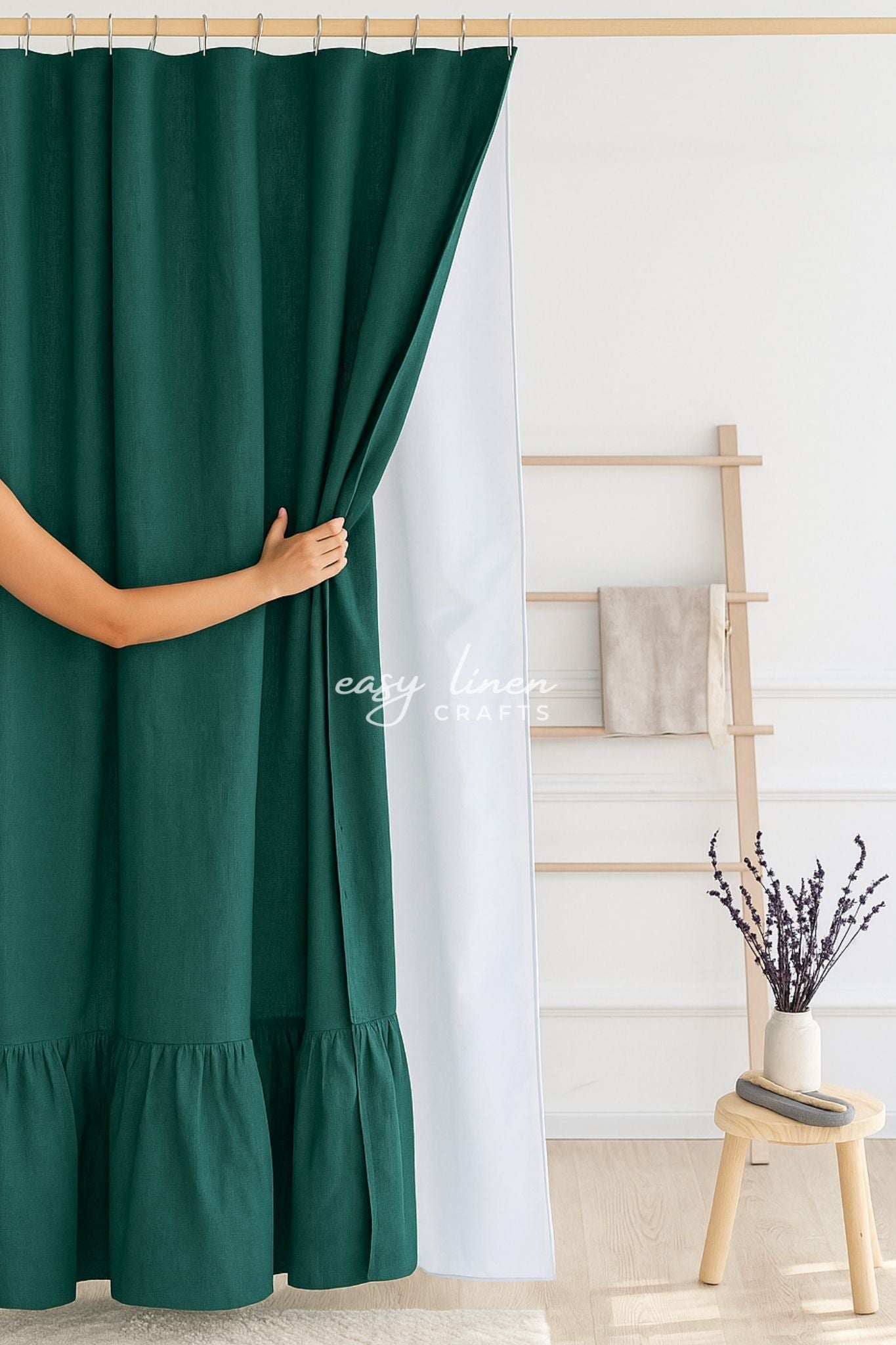 Emerald green shower curtain with a waterproof lining, wooden ladder and plant in the background