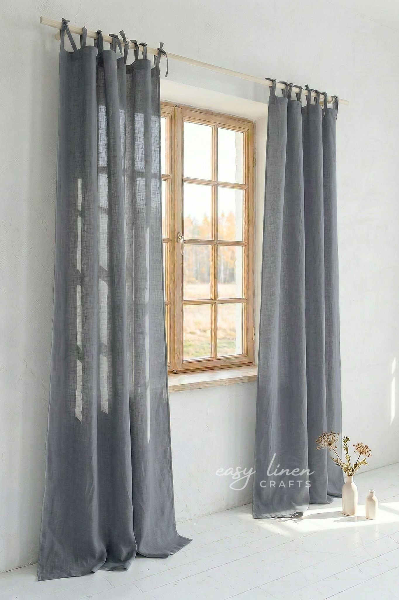 Gray curtains hanging in front of a window with a minimalistic interior.