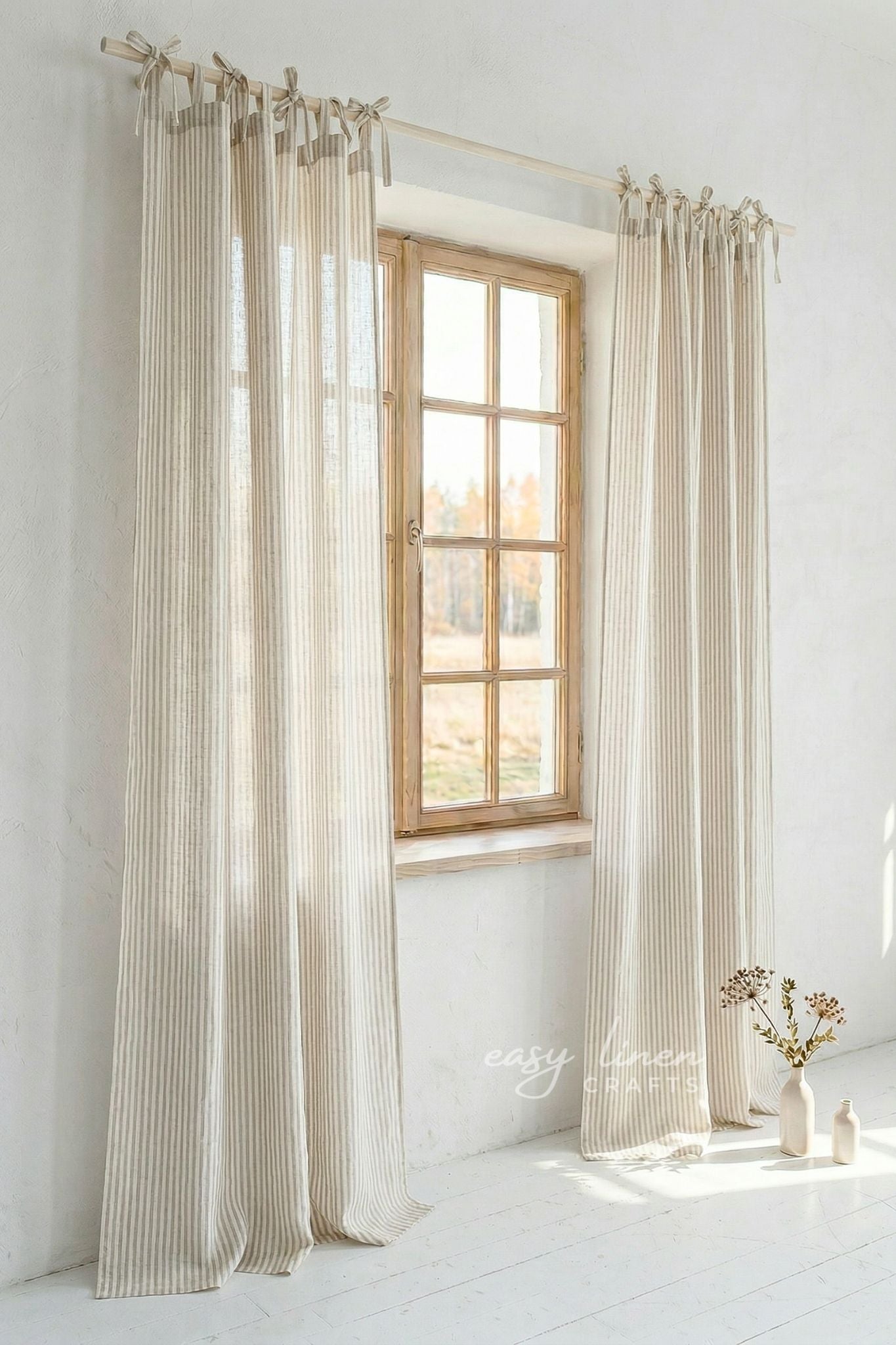 Striped Natural curtains hanging in a window with a white wall background